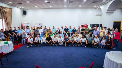 IMG-20260524-WA0161 | MCG24 | موقع إلكتروني مغربي شامل متجدد على مدار الساعة Large group of men and women posing for a group photo in a conference room, with curtains, tables, and decorative arches visible in the background.