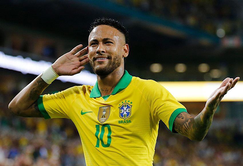 Brazilian soccer player wearing Brazil's yellow jersey with number 10, cupping his ear in celebration.