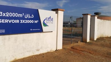Image1 | MCG24 | موقع إلكتروني مغربي شامل متجدد على مدار الساعة Blue sign on a white wall advertising a 3x2000 m³ reservoir, with SRM logo; gate and fencing visible behind.