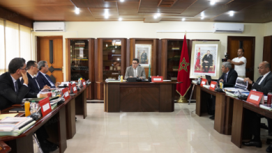 MAP0278965 | MCG24 | موقع إلكتروني مغربي شامل متجدد على مدار الساعة Formal meeting in a conference room with officials seated around two long tables facing a speaker at the head, Moroccan flag nearby.