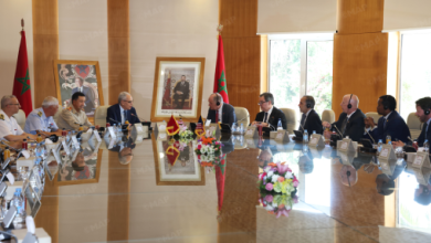 MAP5546_png | MCG24 | موقع إلكتروني مغربي شامل متجدد على مدار الساعة Group of officials in suits seated around a long conference table in a bright room with Moroccan flags and portraits on the walls.