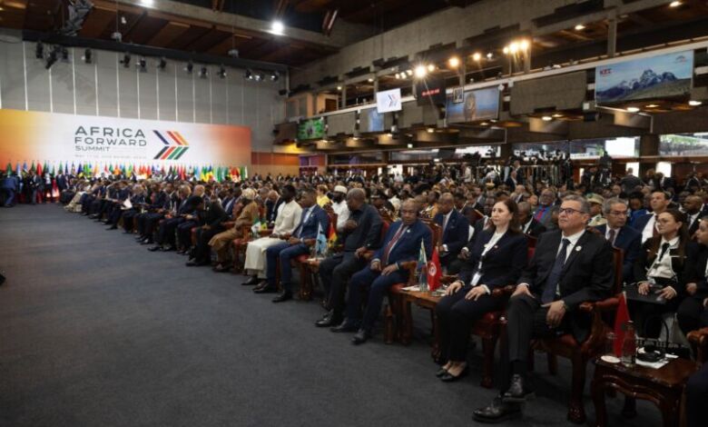 Delegates seated at a large conference hall during the Africa Forward Summit, flags on the tables and a colorful backdrop on stage.