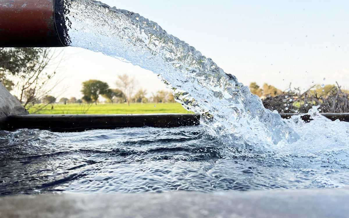 abhshod_blog_img_1 | MCG24 | موقع إلكتروني مغربي شامل متجدد على مدار الساعة Water pouring from a pipe into a trough, with a rural field and trees in the background.