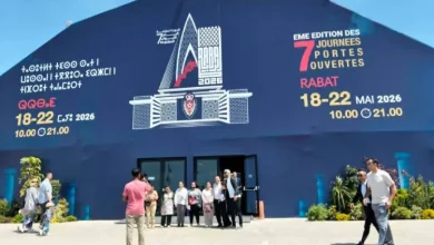Group of people standing outside a large blue event venue with Rabat 'Journées Portes Ouvertes' signage and dates 18–22 May 2026.