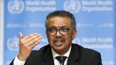img-0429996907 | MCG24 | موقع إلكتروني مغربي شامل متجدد على مدار الساعة Man wearing glasses and a suit speaks at a World Health Organization briefing, gesturing with his right hand in front of a blue WHO backdrop.