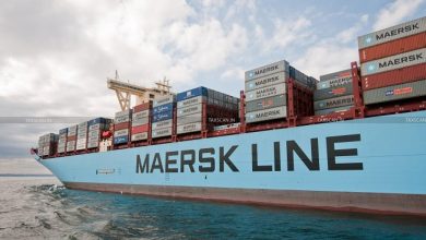 Maersk Line cargo ship with stacked shipping containers on the deck at sea under a partly cloudy sky