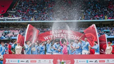 manchester-city-coupe | MCG24 | موقع إلكتروني مغربي شامل متجدد على مدار الساعة Team of players celebrates on stage with confetti and trophy after winning the Emirate Cup 2026 final in a packed stadium, banner reads 'Winners 2026'.