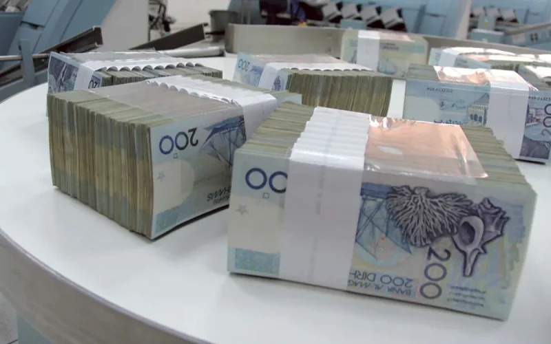Bundles of 200-euro banknotes stacked on a white table, secured with paper bands.
