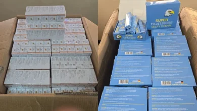 Two open cardboard boxes filled with rows of small cream boxes; left stack has white boxes, right stack has blue boxes labeled 'Delay Cream' with a bird logo.