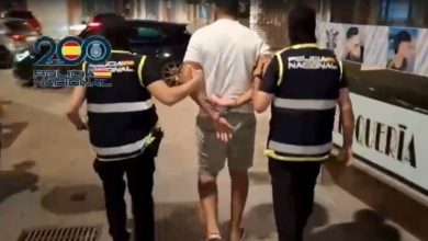 narcos-drones-pasar-hachis-marruecos-espana-4 | MCG24 | موقع إلكتروني مغربي شامل متجدد على مدار الساعة Two police officers walk with a handcuffed man down a city sidewalk at night, one on each side, guiding him toward a police vehicle for transport.