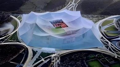 A circular architectural installation with a translucent pleated canopy over a shallow pool, surrounded by curved white walkways.