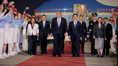 trump | MCG24 | موقع إلكتروني مغربي شامل متجدد على مدار الساعة Delegation arrives on a red carpet at an airport, led by a central group of leaders with flag‑bearing attendants nearby.
