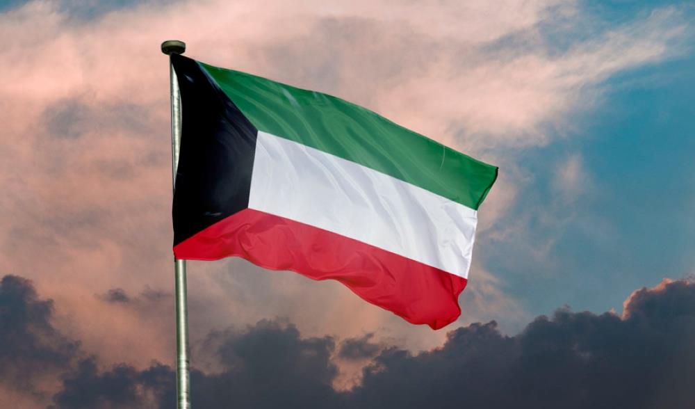 vis_0330202607242394 | MCG24 | موقع إلكتروني مغربي شامل متجدد على مدار الساعة Flag of Kuwait waving in the wind against a cloudy sky, mounted on a flagpole