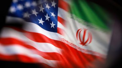 Close-up of the American flag overlapping with the Iranian flag, blurred at the edges.