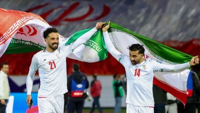 vis_0510202613002601 | MCG24 | موقع إلكتروني مغربي شامل متجدد على مدار الساعة Two Iranian soccer players celebrate, lifting the national flag over their shoulders on a sports field.