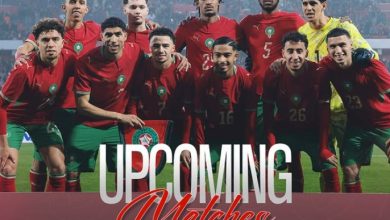 Morocco national football team in red jerseys posing for a group photo on the field, with 'Upcoming Matches' text overlaid.
