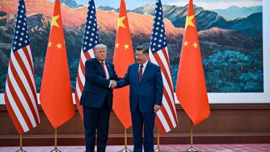 vis_0514202616581477 | MCG24 | موقع إلكتروني مغربي شامل متجدد على مدار الساعة Two world leaders, Donald Trump and Xi Jinping, shake hands in front of alternating US and China flags during a formal meeting backdrop of mountains and a gallery wall.