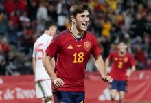 yghuh | MCG24 | موقع إلكتروني مغربي شامل متجدد على مدار الساعة Soccer player in a red Spain jersey number 18 celebrating on the pitch with a cheering crowd behind.