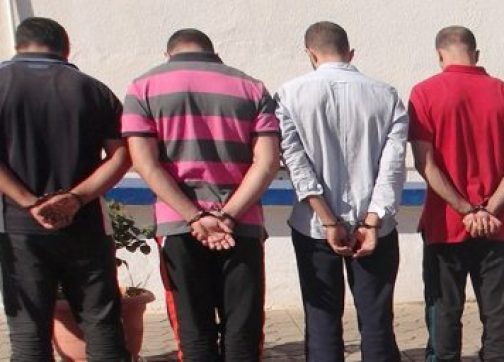 توقيف-4-اشخاص-بالمخدرات-418 | MCG24 | موقع إلكتروني مغربي شامل متجدد على مدار الساعة Four men stand in a line with their hands behind their backs, facing away from the camera outdoors.