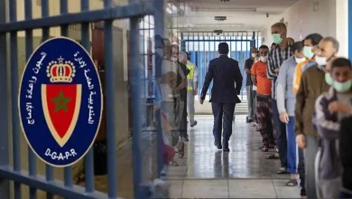 Line of detainees wearing masks standing along a hallway while a suited man walks away; prison bars and a DGAPR sign are visible on the left.