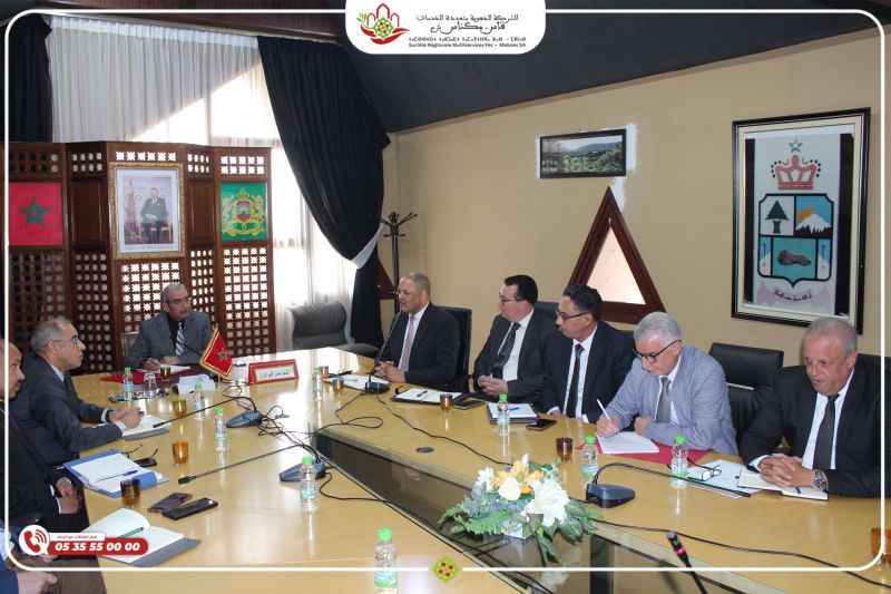 521515454 | MCG24 | موقع إلكتروني مغربي شامل متجدد على مدار الساعة Group of officials in a formal meeting around a long conference table, Moroccan flag and crest visible in the room.