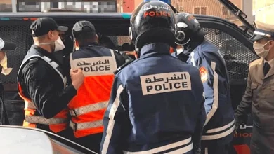 492DAA4A-0E24-4CA5-B396-D6FF02C3DE95 | MCG24 | موقع إلكتروني مغربي شامل متجدد على مدار الساعة Group of police officers in protective gear near a police van, with patches reading POLICE in Arabic and English.