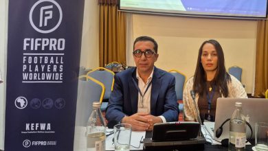 Two panelists sit at a conference table with microphones; a FIFPRO banner stands to the left.