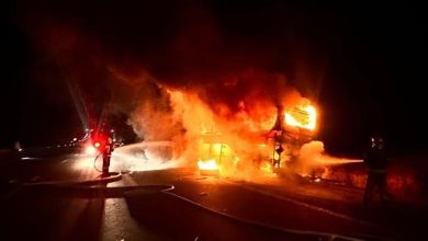 6a1bbc1e42360442dd3073d5 | MCG24 | موقع إلكتروني مغربي شامل متجدد على مدار الساعة Night-time scene of a burning building with flames engulfing the structure as firefighters spray water from hoses nearby.