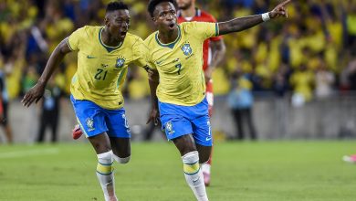 GettyImages-2278485465 | MCG24 | موقع إلكتروني مغربي شامل متجدد على مدار الساعة Two Brazil players celebrate a goal, wearing yellow jerseys and blue shorts on a grass pitch with a cheering crowd in yellow in the background, one pointing ahead.