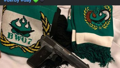 IMG-20260607-WA0032 | MCG24 | موقع إلكتروني مغربي شامل متجدد على مدار الساعة Pistol lying on a white surface between two green-and-white scarves with embroidered logos, and a small plastic bag nearby.