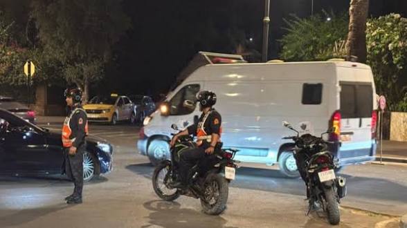 IMG-20260608-WA0124 | MCG24 | موقع إلكتروني مغربي شامل متجدد على مدار الساعة Nighttime scene with two police officers on motorcycles directing traffic near a white van.