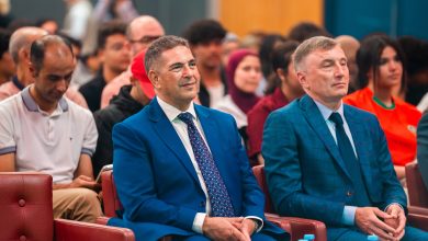 IMG-20260613-WA0060 | MCG24 | موقع إلكتروني مغربي شامل متجدد على مدار الساعة Two men in blue suits sit in the front row of a crowded, formal event audience.