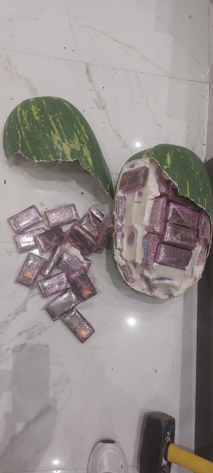 IMG-20260621-WA0263 | MCG24 | موقع إلكتروني مغربي شامل متجدد على مدار الساعة Halved watermelon with purple square candies spilling onto a white surface.