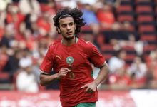 IMG_3239-1024x710 | MCG24 | موقع إلكتروني مغربي شامل متجدد على مدار الساعة Soccer player in a red jersey with number 6, running on the field during a match, with blurred stadium crowd in the background.