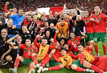 Maroc1670876617665-format16by9 | MCG24 | موقع إلكتروني مغربي شامل متجدد على مدار الساعة Morocco national football team celebrates victory on the field with fans cheering in red in the stands behind them.