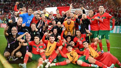 Maroc1670876617665-format16by9 | MCG24 | موقع إلكتروني مغربي شامل متجدد على مدار الساعة Morocco national football team celebrates victory on the field with fans cheering in red in the stands behind them.