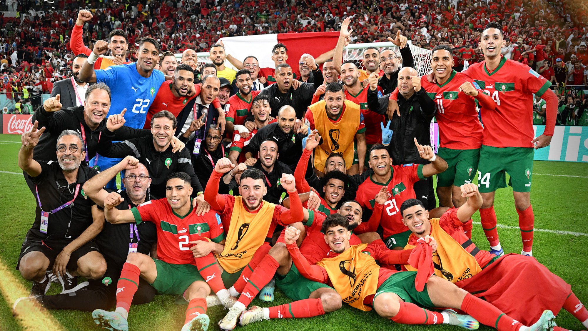 Maroc1670876617665-format16by9 | MCG24 | موقع إلكتروني مغربي شامل متجدد على مدار الساعة Morocco national football team celebrates victory on the field with fans cheering in red in the stands behind them.