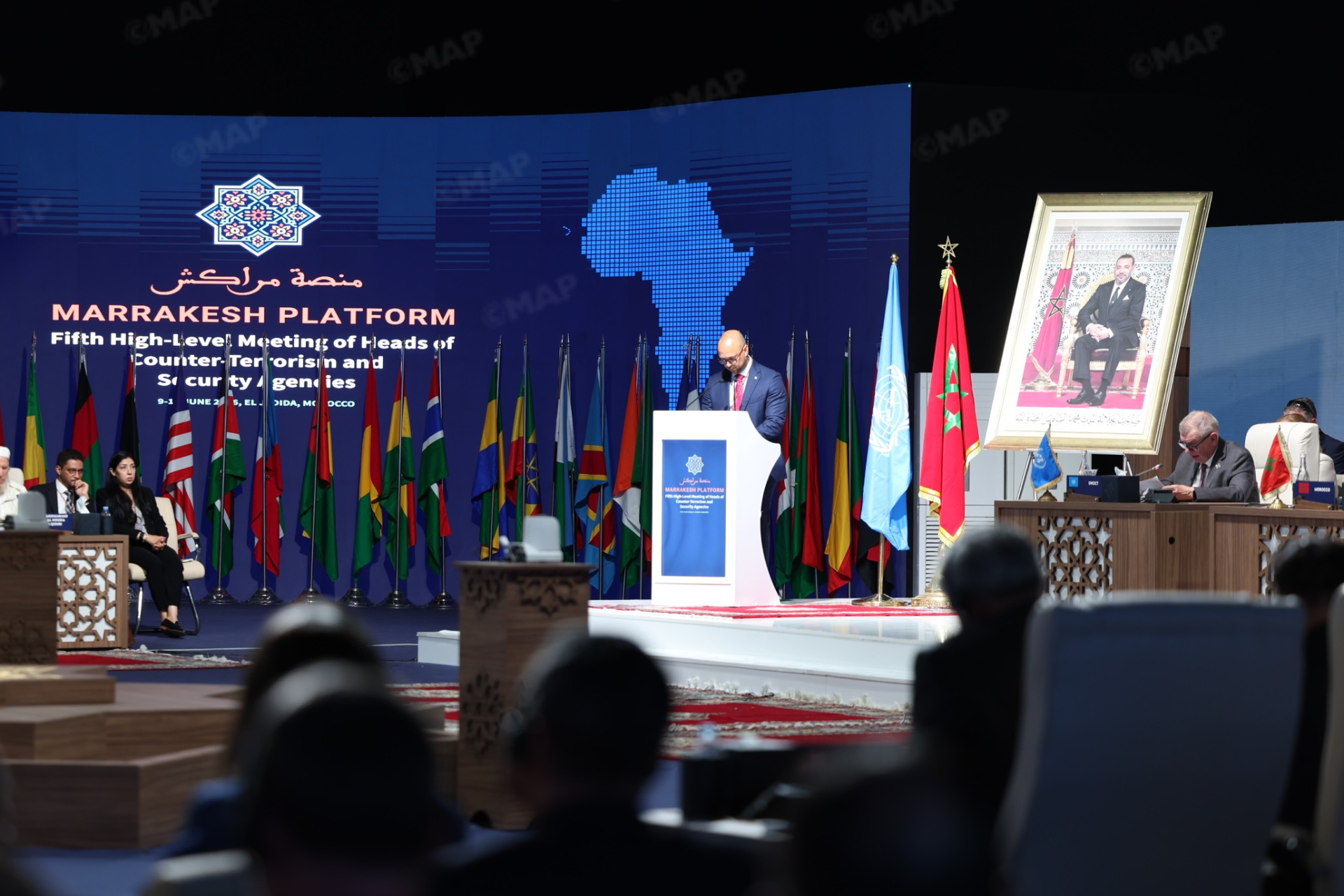 Reunion | MCG24 | موقع إلكتروني مغربي شامل متجدد على مدار الساعة Speaker at a podium delivering a speech on a blue Marrakech Platform stage with many national flags behind him