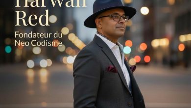 Portrait of Harwan Red, founder of Neo Codisme, in a dark suit and fedora on a bustling city street at dusk with bokeh lights behind him.