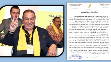 WhatsApp Image 2026-06-12 at 124545 | MCG24 | موقع إلكتروني مغربي شامل متجدد على مدار الساعة Smiling man in a navy suit and yellow scarf shows a peace sign at a conference, with another man in the background; on the right is a formal Arabic document with signatures.