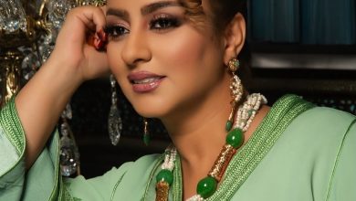 WhatsApp Image 2026-06-22 at 092648 | MCG24 | موقع إلكتروني مغربي شامل متجدد على مدار الساعة Portrait of a woman in a green traditional outfit, resting her head on her hand, wearing layered pearl and green bead jewelry.