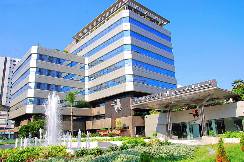 Modern multi-story bank building with a fountain in the foreground and a Banque Populaire sign.