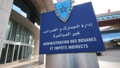 douane | MCG24 | موقع إلكتروني مغربي شامل متجدد على مدار الساعة Blue outdoor sign with government emblem reading 'Administration des Douanes et Impôts Indirects' in French and Arabic, at a border/customs building entrance.
