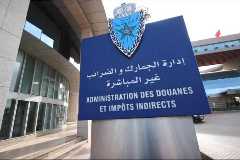 Blue sign at a government building reading 'Administration des Douanes et Impôts Indirects' with crest above.