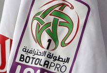 Close-up of a BOTOLA PRO banner with a green abstract soccer ball logo and Arabic text on a white background.