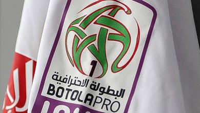 Close-up of a BOTOLA PRO banner with a green abstract soccer ball logo and Arabic text on a white background.