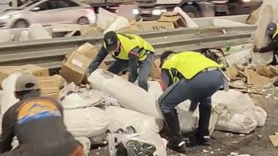 hadit-2 | MCG24 | موقع إلكتروني مغربي شامل متجدد على مدار الساعة Workers in high-visibility vests sorting through a pile of trash and debris along a highway barrier guardrail.