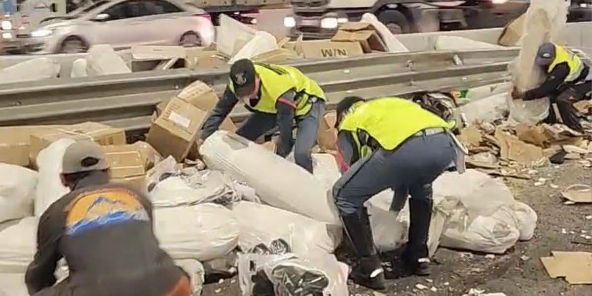 hadit-2 | MCG24 | موقع إلكتروني مغربي شامل متجدد على مدار الساعة Workers in high-visibility vests sorting through a pile of trash and debris along a highway barrier guardrail.