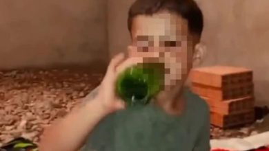 hala | MCG24 | موقع إلكتروني مغربي شامل متجدد على مدار الساعة Person drinking from a green bottle in a dim indoor setting; face blurred for privacy.