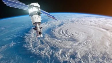illliom | MCG24 | موقع إلكتروني مغربي شامل متجدد على مدار الساعة Satellite docked to space station above a massive hurricane seen from space, with Earth’s curved horizon in the background